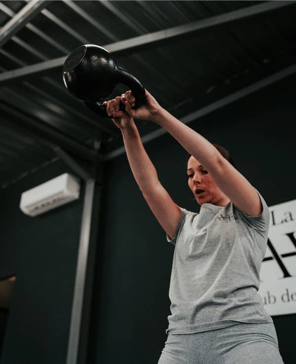 Photo d'une séance renforcement musculaire : Une abonnée s'entraînant à l'aide d'une kettlebell